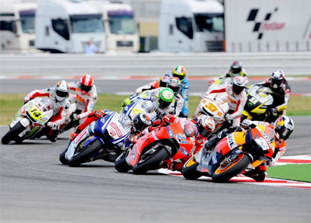 It was bright out there... Pedrosa leads Stoner and Lorenzo out of turn two, lap one. Impending disater behind not shown... (Pic: MotoGP.com)