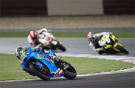 Loris Capirossi leads Colin Edwards. Check out the one-off helmet design to celebrate 300 starts... (Suzuki)