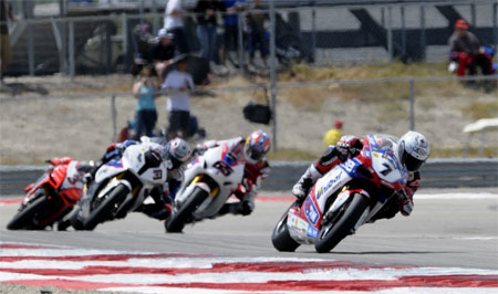 Carlos Checa making the most of the bare knuckle fight between Rea and Melandri behind him...(Pic: InFront)